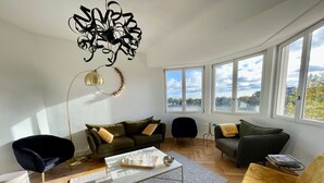 A modern living room with a sofa, chairs, a coffee table, and large windows offering a view. - MAGNIFICENT VIEW HOUSE PARADISIAC IN THE MIDDLE OF VINES OF BOURGOGNE (Rully)