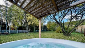 A hot tub in a backyard with a pergola overhead, surrounded by trees and a grassy area. - MAGNIFICENT VIEW HOUSE PARADISIAC IN THE MIDDLE OF VINES OF BOURGOGNE (Rully)