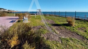 En kuststig med en bänk, ett staket och utsikt över havet.