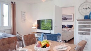 Ein modernes Hotelzimmer mit Essbereich, Fernseher und Bett.