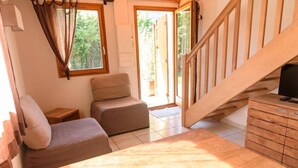 A cozy room with a wooden staircase, a small sofa, a wooden cabinet, and a window with curtains. - Aurore du Lac - Duplex Apartment (1-2 Adults) (Sevrier)