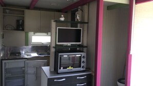 Une cuisine compacte équipée d’un four à micro-ondes, d’un petit réfrigérateur et d’un évier.