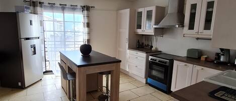 Una cocina con refrigerador, estufa y alacenas.