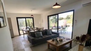 Un salon moderne avec un canapé, une table basse et un coin repas.