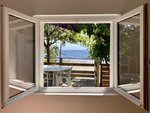 Ein Zimmer mit Meerblick, ein Tisch mit Stühlen und eine Holterrasse.