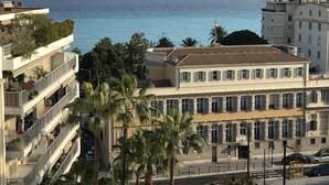 Un bâtiment situé sur la côte, doté de nombreux balcons qui offrent une vue sur la mer.
