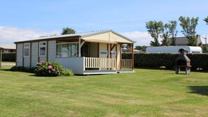 A small, single-story mobile home with a porch and a fenced garden area. - panoramic sea view chalet, chalet club 8 (Plomodiern)