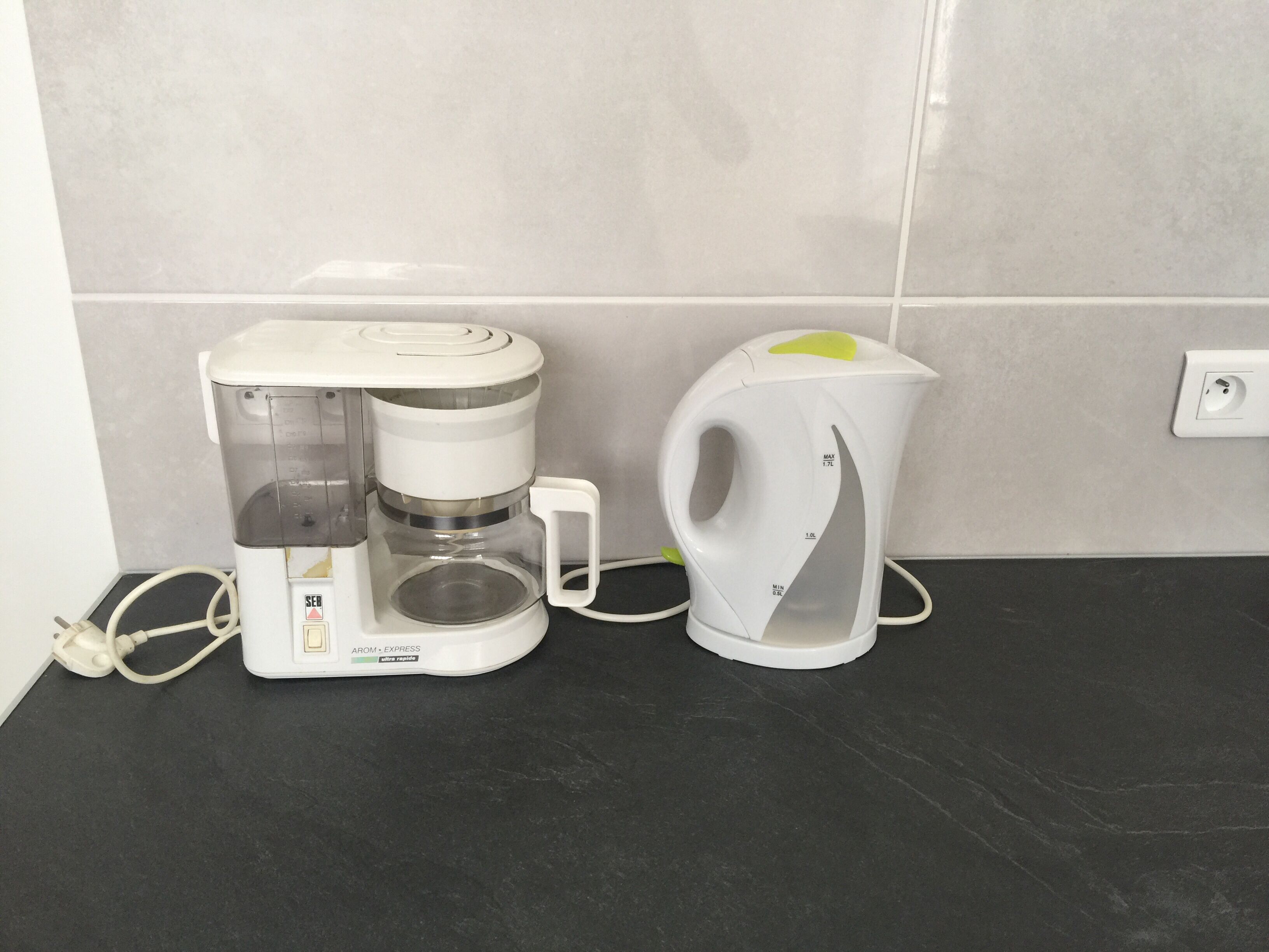 Une machine à café et une bouilloire sur un plan de travail.
