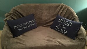 Uma poltrona marrom com duas almofadas decorativas.