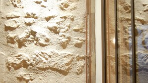 Eine strukturierte Wand mit einem kleinen, ankerförmigen Ornament.