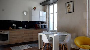 Une cuisine moderne avec des meubles en bois, une table à manger blanche et une chaise jaune.