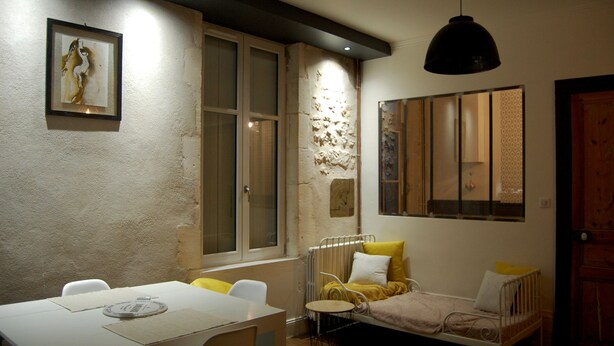 Ein gemütliches Zimmer mit einem Bett, einem Tisch und Stühlen. Ein Fenster bietet Blick ins Freie.