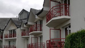 A multi-story building with balconies, a parking sign, and a gated entrance. - very nice studio DINARD / LA RICHARDAIS 5 minutes from the beach (LA RICHARDAIS)