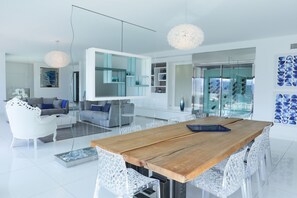 A modern kitchen with a central island, white cabinetry, and a large window.