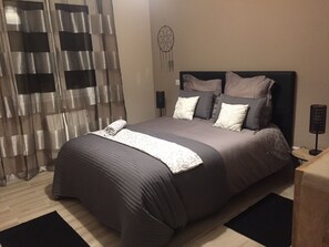 A neatly made bed with a patterned bedspread, pillows, and a folded blanket. - Brand new holiday villa  (Bompas)