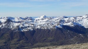 A mountainous landscape with snow-covered peaks and a clear sky. - At the heart of the resort Lioran (Laveissière)