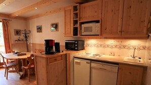 A compact kitchen with wooden cabinets, a microwave, a coffee maker, and a dishwasher. - Functional apartment for 4-6 people with pool, TV, dishwasher and balcony in Arêches-Beaufort (Arêches-Beaufort)