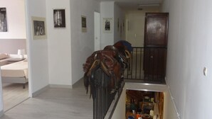 A hallway with a bed, a wooden cabinet, and a staircase. - HARAS DU CROC MARIN Principal (Montigny-sur-Loing)