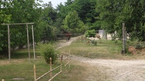 A dirt path leading to a fenced area with a horse visible in the distance. - HARAS DU CROC MARIN Principal (Montigny-sur-Loing)