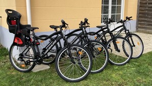 Diverse biciclette parcheggiate contro un edificio con una finestra e una porta.