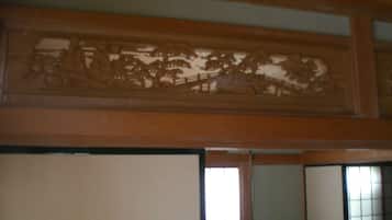 Een traditionele Japanse kamer met tatami vloeren, een shoji schuifdeur en een houten plafond.