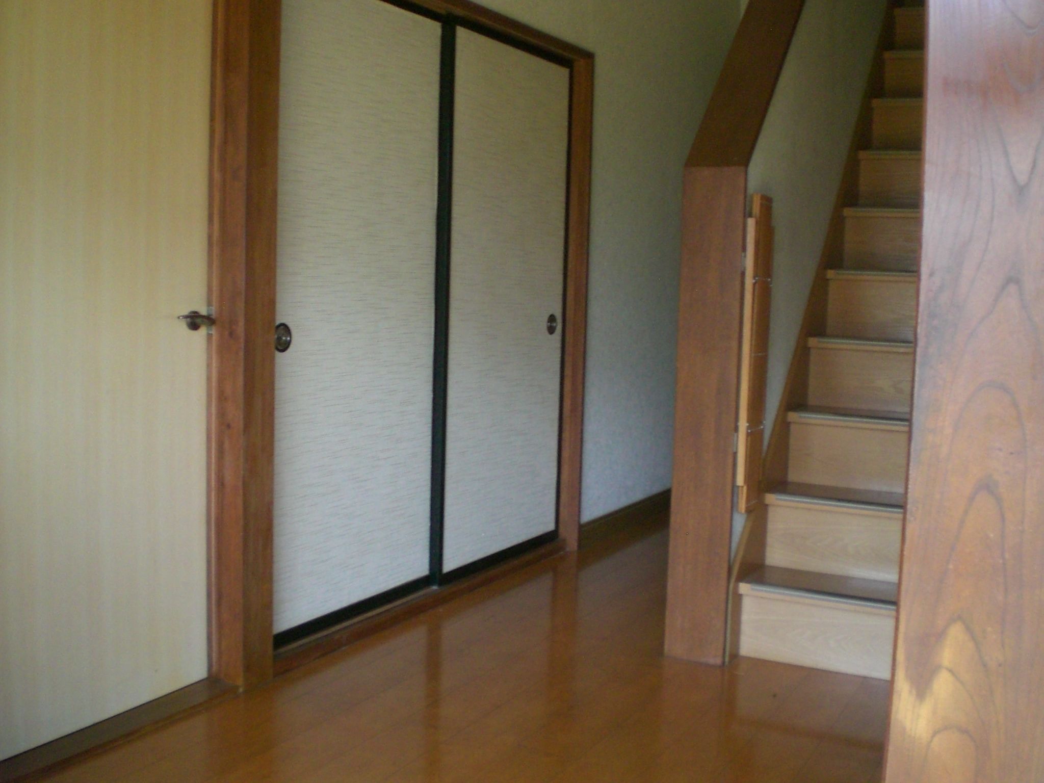 A wooden staircase leading to a room with a sliding door.