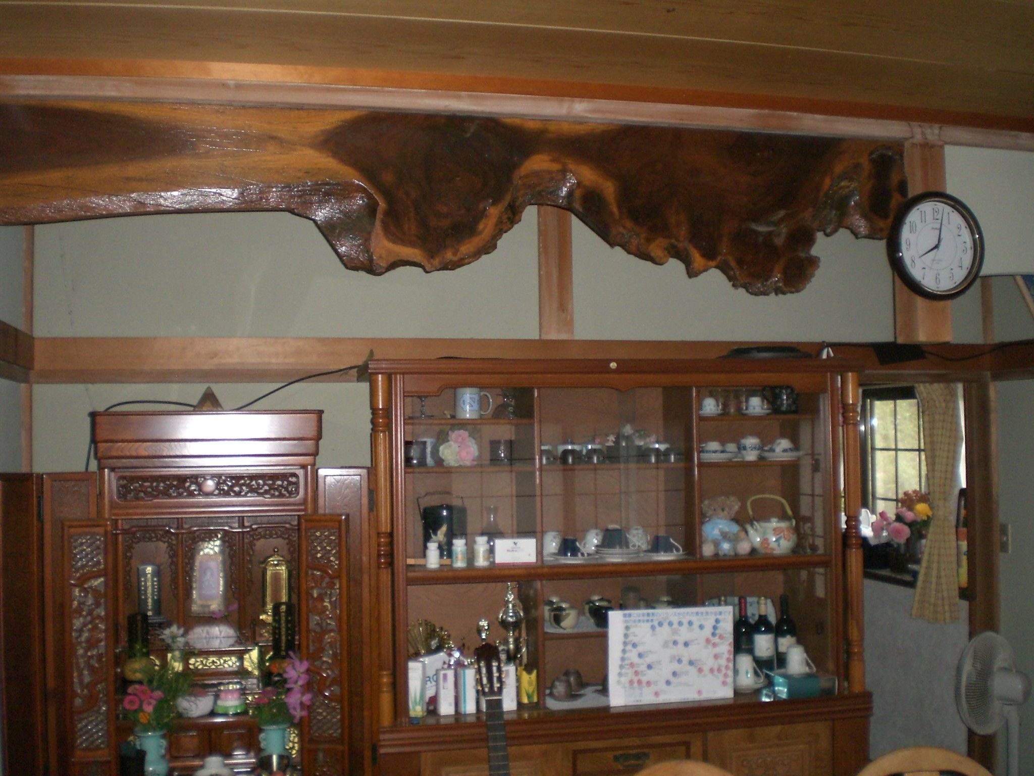 A wooden cabinet with glass doors containing various kitchen items.