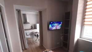 A living room with a TV, a dining area, and a kitchen in the background. - Apartment 100 refurbished !!!! 07/2019 !!!! 35 M2 (3 beds)   (Bourg-Saint-Andéol)
