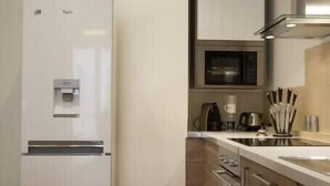 A modern kitchen with a built-in refrigerator, microwave, and oven. - 🎖 Pretty 3 rooms in the city center (Annecy)