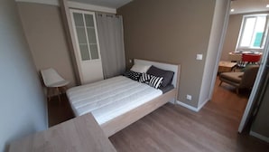 A bedroom with a bed, a desk, a chair, and a window with curtains. - Apartment 101 refurbished !!!! 07/2019 !!!!  45 M2 (sleeps 4)   (Pierrelatte)