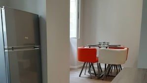 A modern kitchen with a stainless steel refrigerator, a wooden countertop, and a dining area with red chairs. - Apartment 101 refurbished !!!! 07/2019 !!!!  45 M2 (sleeps 4)   (Pierrelatte)
