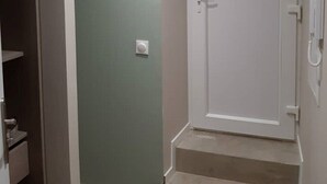 A room with a green wall, a white door, and a set of beige stairs leading to a landing. - Apartment 101 refurbished !!!! 07/2019 !!!!  45 M2 (sleeps 4)   (Pierrelatte)