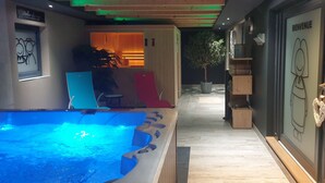 A spa area with a hot tub, wooden flooring, and a reception desk. - La Griffe à Foin, Kaysersberg - 300 m² House - Private Jacuzzi Sauna  (Kaysersberg)