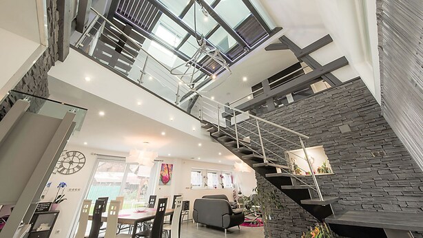 A spacious interior with a high ceiling, a staircase leading to an upper level, and a dining area with chairs and a table. - La Griffe à Foin, Kaysersberg - 300 m² House - Private Jacuzzi Sauna  (Kaysersberg)