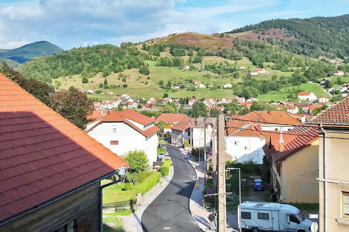 A rural village with houses, a road, and a mountain in the background.