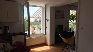 Une cuisine moderne avec une grande fenêtre, un coin repas avec une chaise et une petite table.