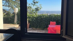 Una cocina con vista a la ciudad por la ventana, un fregadero y una planta en maceta.