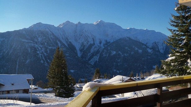 Eine Berglandschaft mit schneebedeckten Gipfeln und blauem Himmel.