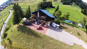 Eine Lodge mit einem großen Gebäude, Außenbereich und einem Parkplatz.