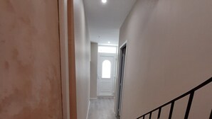 Una escalera que conduce a un rellano con una puerta al final.