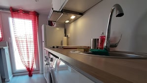 Una cocina moderna con encimera de madera, pileta de acero inoxidable y lavadora.
