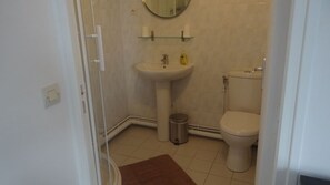 Une petite salle de bain avec un lavabo, des toilettes et un miroir au-dessus du lavabo.