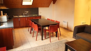 Una cocina compacta con comedor, un sofá y una pequeña mesa.