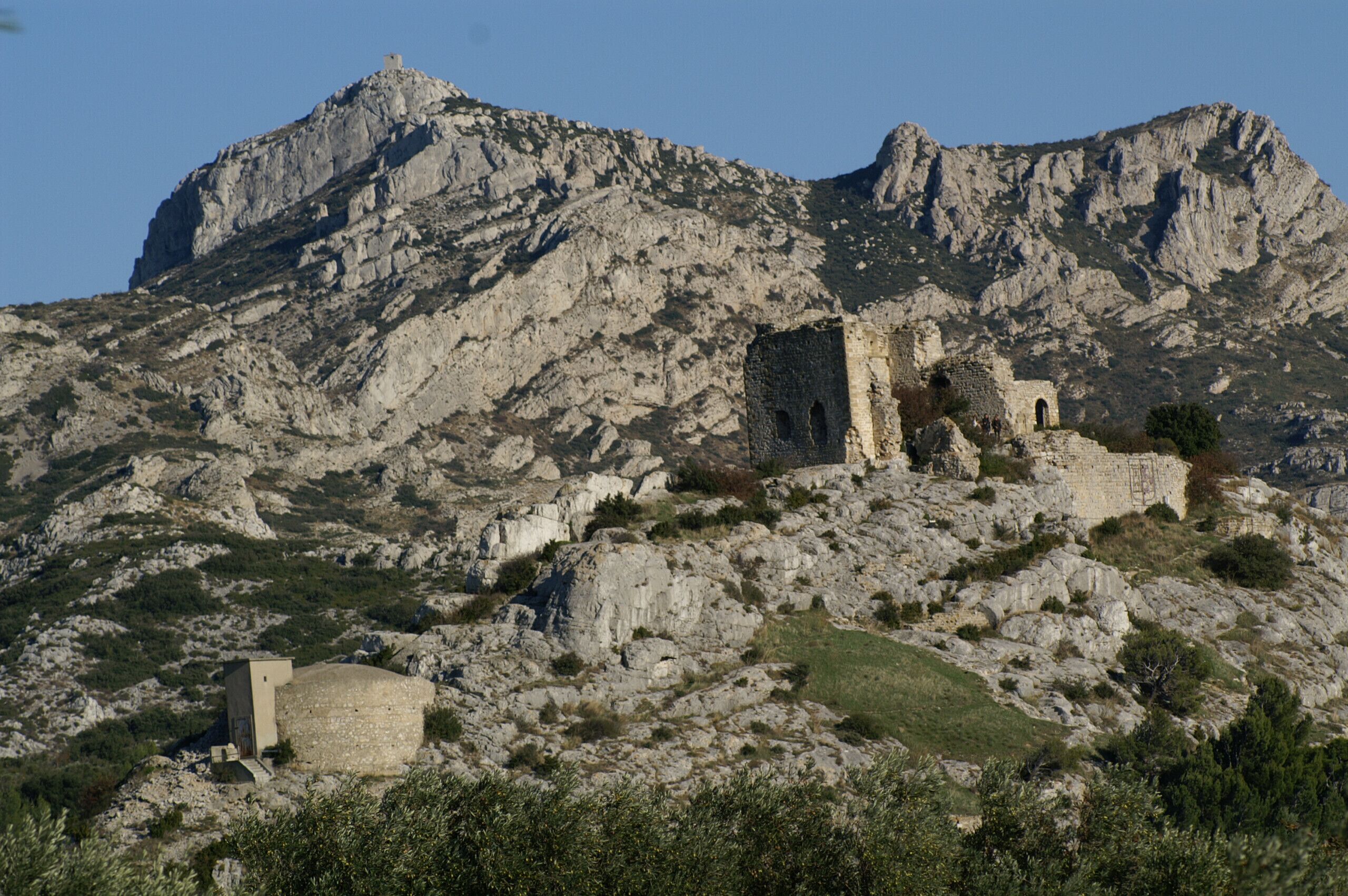 A mountainous landscape with ancient ruins and a small building.