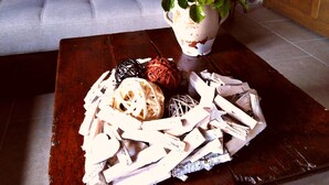 A wooden coffee table with a white vase containing a bouquet of flowers and decorative items. - Welcome to "La Ferme des Tilleuls" (Courset)