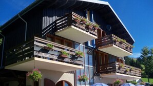A two-story building with balconies, outdoor seating, and potted plants. - RENT APARTMENT IN THE MOUNTAIN - PIERRA MENTA (Villard-Sur-Doron)