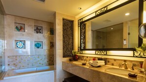 Un baño con un espejo grande, dos lavamanos y azulejos decorativos.