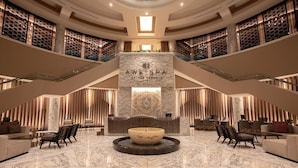 A spacious lobby with a central fountain, a reception desk, and a staircase leading to an upper level. - Luxury Suite in Moon Palace  Cancún (Cancún)