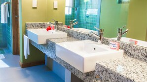 A bathroom with two sinks, a large mirror, and green walls. - Residence Bel Eau (Mahé Island)
