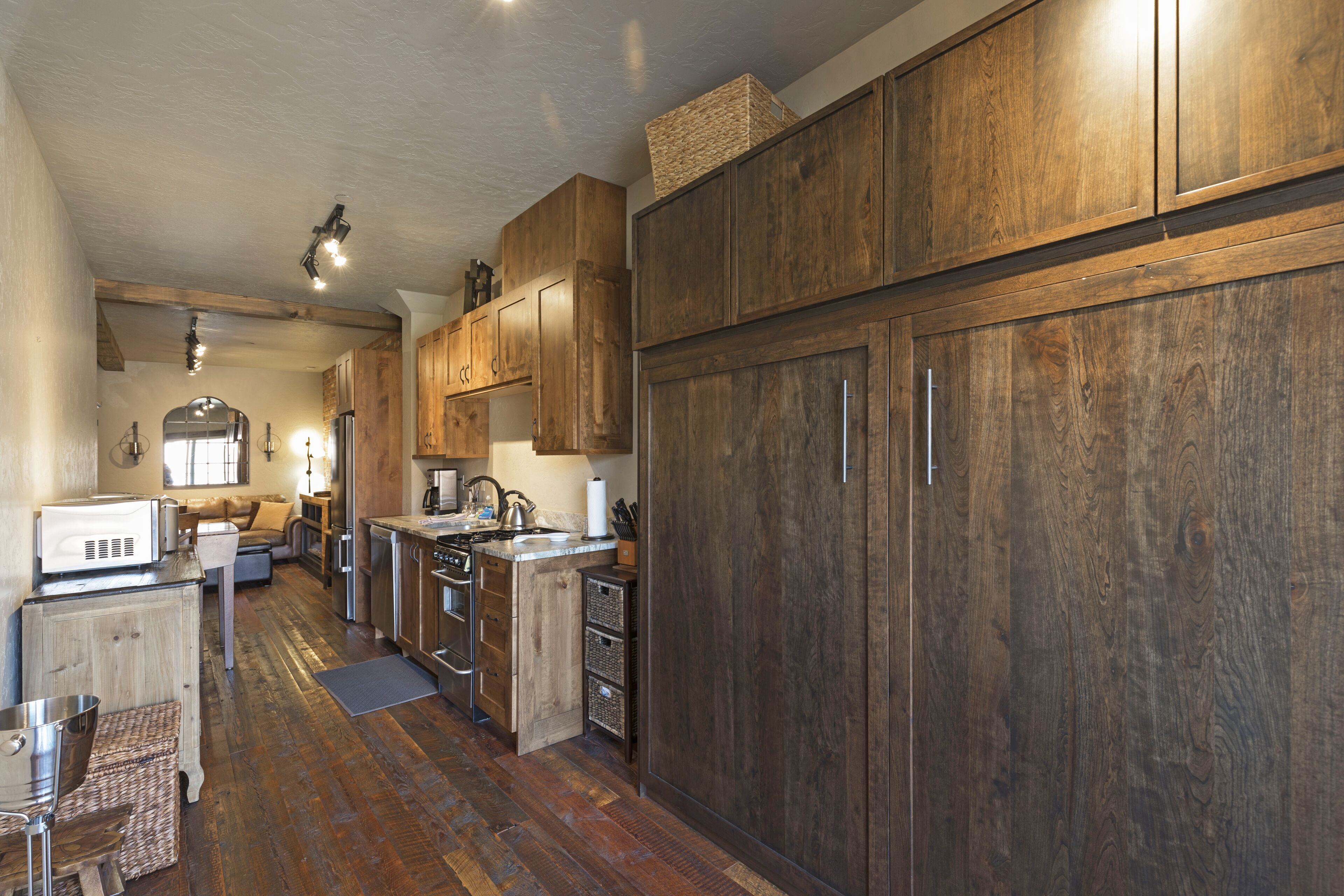 A kitchen with wooden cabinets, a microwave, and a sink.